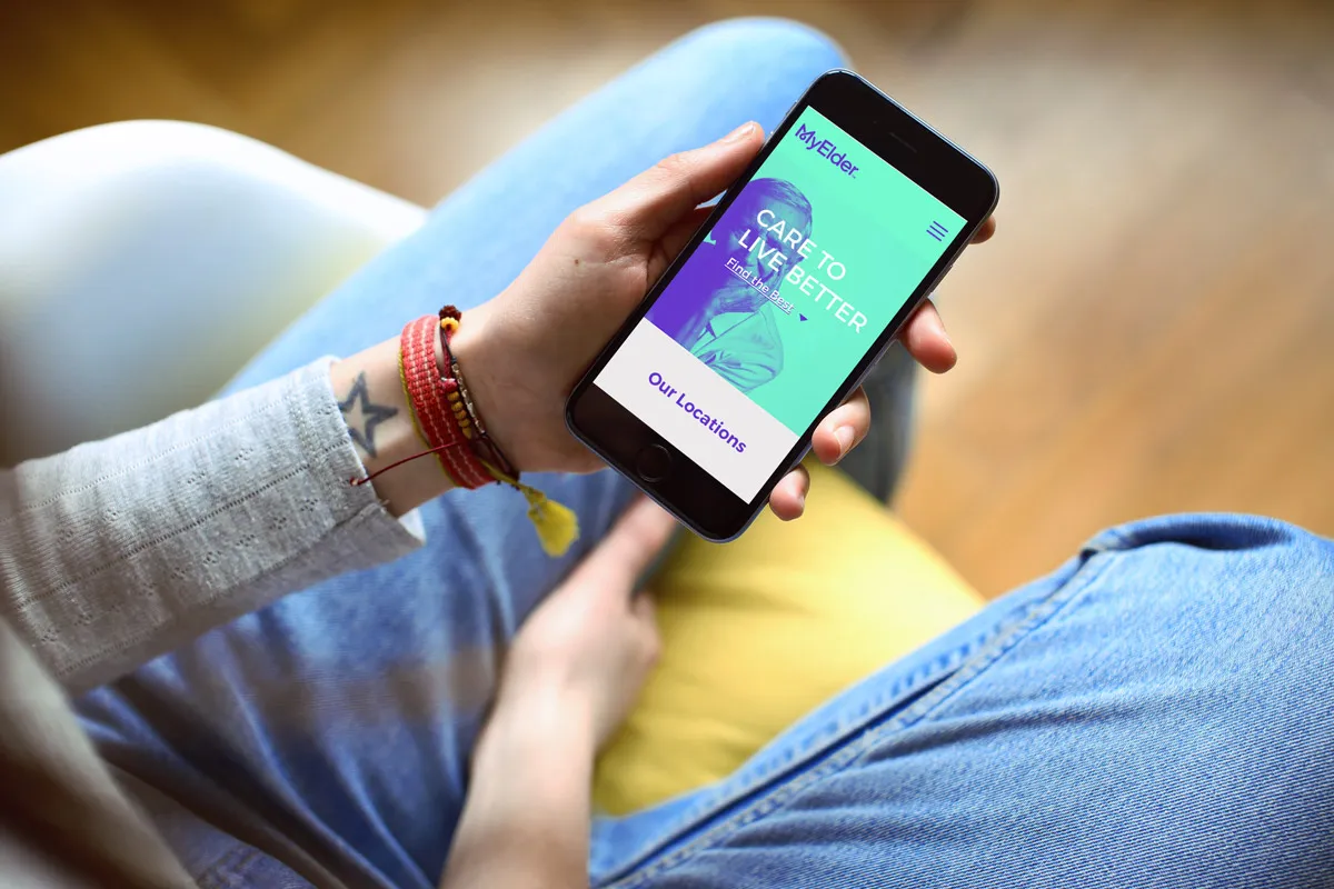 The Myelder mobile site — "Care to live better" — shown on a phone in hand