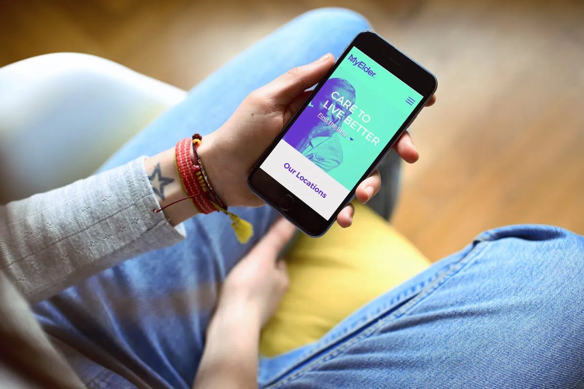 The Myelder mobile site — "Care to live better" — shown on a phone in hand