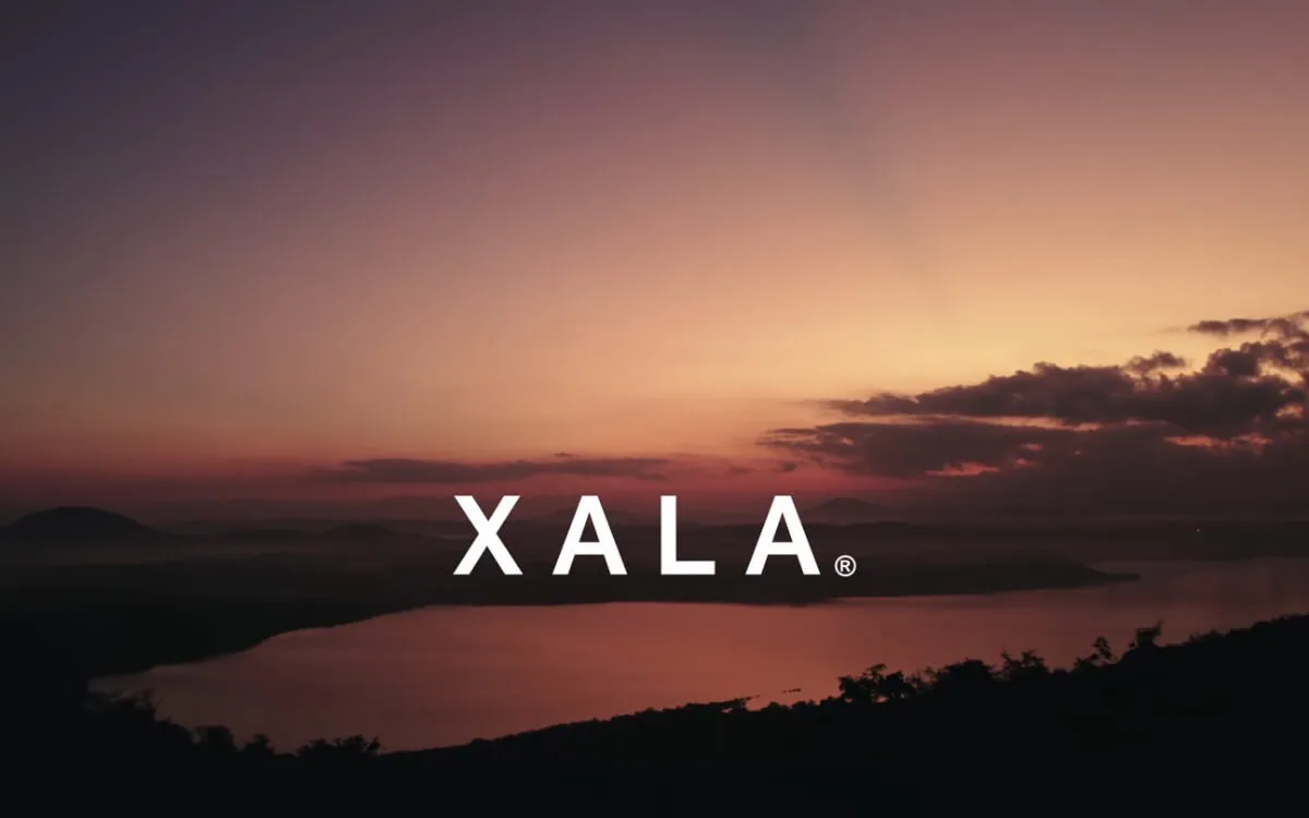 The Xala website hero — the XALA wordmark over a sunset across the coastline